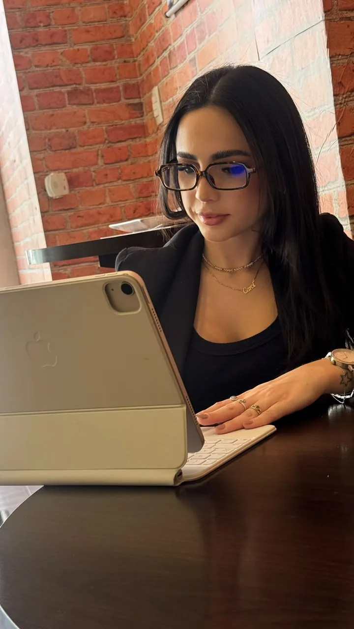 Carolina em seu consultório, usando um tablet